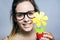 Beautiful young woman showing one artificial daisy