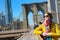 Beautiful young woman sightseeing on Brooklyn Bridge, New York