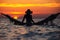 Beautiful young woman silhouette with swing posing in the sea on sunset, maldivian romantic scenery