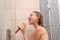 Beautiful young woman singing in shower