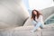 A beautiful young woman sits on the steps of the Walt Disney Concert Hall. Popular destination for sightseeing in Los Angeles