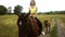 Beautiful young woman sitting astride a horse and goes down the street