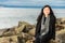 Beautiful Young Woman Sitting on Beach Driftwood