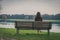 Beautiful young woman sitting on a bench in a city park