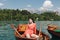 beautiful young woman sitting in boat at scenic tranquil mountain lake