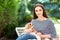 Beautiful young woman sitting in chair outdor with her cute cavalier puppy