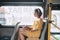 Beautiful young woman sitting in city bus and writing some notes in notebook