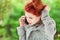 Beautiful young woman sitting in the garden having a conversation on her cell phone