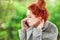 Beautiful young woman sitting in the garden having a conversation on her cell phone