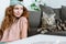 beautiful young woman sitting near adorable tabby cat