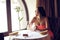 Beautiful young woman sitting at the table alone in a restaurant