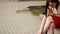 Beautiful young woman smiles mysteriously, sitting on a bench in a summer park. Portrait of a woman outdoors.