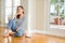 Beautiful young woman smiling confident and thinking positive sitting on the floor at home in the morning