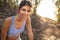 Beautiful young woman in sportswear relaxing after trail run training. Female trail runner taking break after running workout on