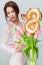 Beautiful young woman with spring tulips flowers bouquet. Happy girl smiling holds flowers, pink tulip. Spring portrait