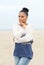 Beautiful young woman standing alone on beach