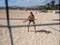 Beautiful young woman is standing at the beach volleyball court