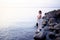 Beautiful Young Woman Staying on Seashore Stones