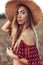 Beautiful and young woman straw hat in summer in field. Concept village girl nature. Emotions tenderness, elegance