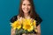 Beautiful young woman with sunflowers on color background