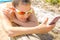 Beautiful young woman in sunglasses lies at the bottom and takes a sun bath and reads a smartphone