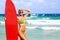 Beautiful young woman surfer girl in bikini with red surfboard a