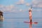 Beautiful young woman surfing on stand up paddle