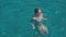 Beautiful young woman swims in clear blue water near Formentera or Ibiza islands around luxury yach. Slow motion