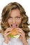 Beautiful young woman taking bite of hamburger