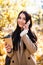 Beautiful young woman talking smartphone walking colorful autumn street