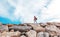 Beautiful young woman traveler walking on rocks rocks against th