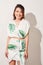 Beautiful young woman in tropical print green and white dress