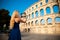 Beautiful young woman turist taking photos of roman arena in Pula croatia