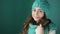 Beautiful young woman in a turquoise knitted hat and scarf