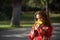 Beautiful young woman in a typical Moroccan red suit, embroidered with gold and silver threads, smelling a yellow pacific flower.