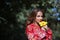 Beautiful young woman in a typical Moroccan red suit, embroidered with gold and silver threads, with a yellow pacific flower in