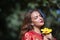 Beautiful young woman in a typical Moroccan red suit, embroidered with gold and silver threads, with a yellow pacific flower in