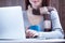 beautiful young woman typing text and holding a cup on the wonderful wooden background