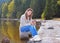 Beautiful young woman using smartphone near a lake