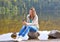 Beautiful young woman using smartphone near a lake