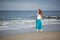 Beautiful young woman walks along the ocean