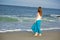Beautiful young woman walks along the ocean