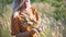 Beautiful young woman walks in the field collects a bouquet of flowers and spikelets. Portrait of attractive female on grass at su