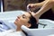 Beautiful young woman washes hair in a beauty salon.