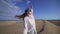 Beautiful young woman waving and stretching in the windy dunes in the desert. Gran Canaria, Spain