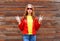 Beautiful young woman wearing a red leather jacket in autumn over wooden