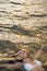 Beautiful young woman in white bikini laying down in the sea water. Sunset golden light. Calm, serene people