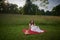 Beautiful young woman in white dress on picnic blanket on summer afternoon