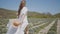 Beautiful young woman in white dress runs across field. Action. Woman's hair and dress flutter beautifully while running