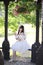 Beautiful young woman with white lolita dress with european garden Japanese fashion